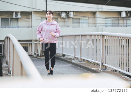 屋外でジョギングする30代女性 健康的なランニング習慣 フィットネスイメージ 137272153