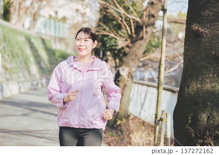 屋外でジョギングする30代女性 健康的なランニング習慣 フィットネスイメージ 137272162