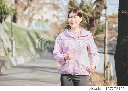 屋外でジョギングする30代女性 健康的なランニング習慣 フィットネスイメージ 屋外でジョギングする30代女性 健康的なランニング習慣 フィットネスイメージ 137272163