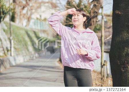屋外でジョギングする30代女性 健康的なランニング習慣 フィットネスイメージ 屋外でジョギングする30代女性 健康的なランニング習慣 フィットネスイメージ 137272164