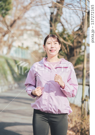 屋外でジョギングする30代女性 健康的なランニング習慣 フィットネスイメージ 137272165