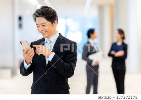 スマホを見る中年男性 137272178