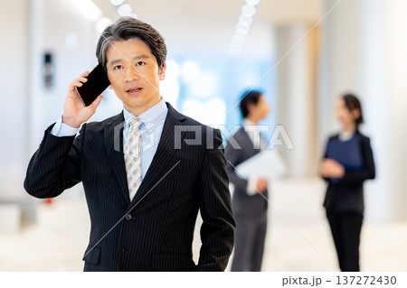 スマホで電話をする経営者の男性 137272430
