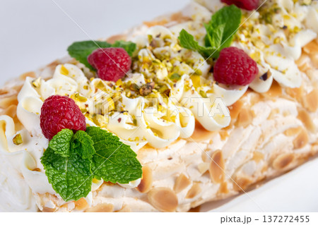 Meringue cream cheese roll with raspberries, mint and nuts. 137272455