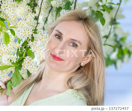 Portrait of a woman with natural beauty at the blooming tree in spring. 137272457