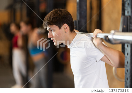 Man with a barbell in the hall 137273818