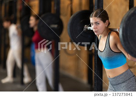 Woman doing strength training with a barbell 137273841
