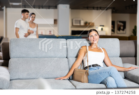 Young girl choosing convenient sofa in furniture shop Young girl choosing convenient sofa in furniture shop 137274258