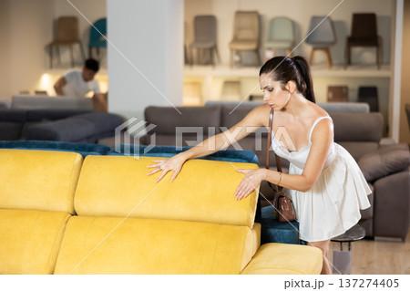 Adult woman chooses sofa in store Adult woman chooses sofa in store 137274405