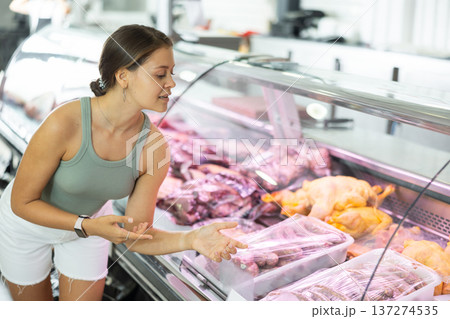 Young woman purchaser buying sausages in butcher shop Young woman purchaser buying sausages in butcher shop 137274535