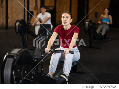 Woman exercising on a rowing machine 137274732