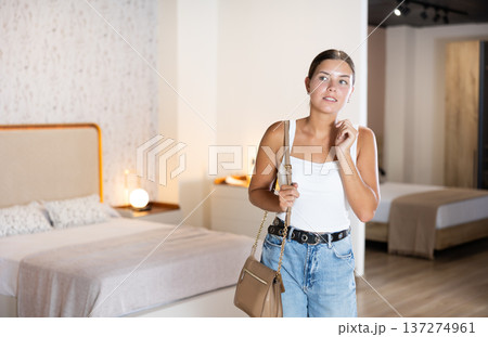 Young girl choosing convenient mattress in furniture shop 137274961
