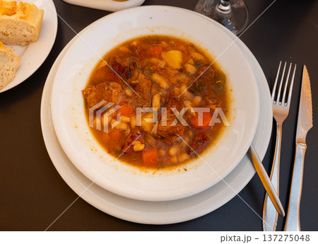 Restaurant serves chickpea and bean soup, served in portions on white plate Restaurant serves chickpea and bean soup, served in portions on white plate 137275048