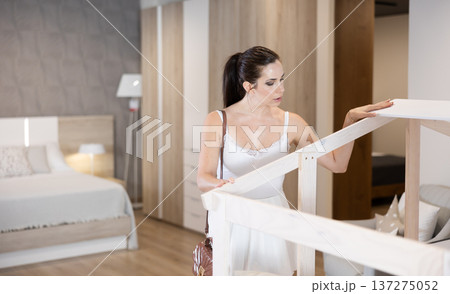Adult woman looking around in bedroom department Adult woman looking around in bedroom department 137275052