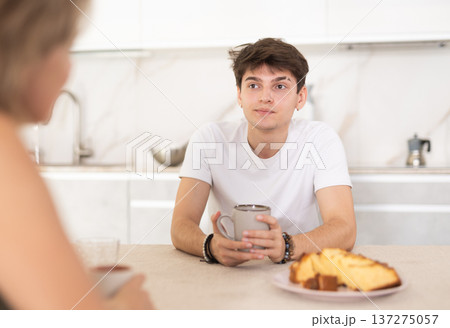 Couple sitting at kitchen table and drinking tea at home Couple sitting at kitchen table and drinking tea at home 137275057
