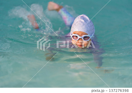 preschool child girl playing and swimming in pool preschool child girl playing and swimming in pool 137276398