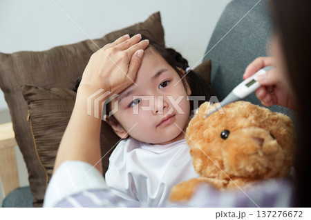 Sick child cuddling teddy bear. Mother providing care and comfort. Sick child cuddling teddy bear. Mother providing care and comfort. 137276672