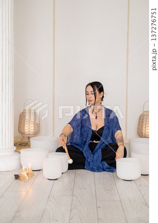 Sound meditation. Healing therapy. Woman playing crystal singing white bowls wellness retreat steam fire candles for spiritual treatment. Sound meditation. Healing therapy. Woman playing crystal singing white bowls wellness retreat steam fire candles for spiritual treatment. 137276751