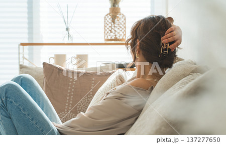 リビングのソファでリラックスするおしゃれな主婦のアジア人女性 137277650