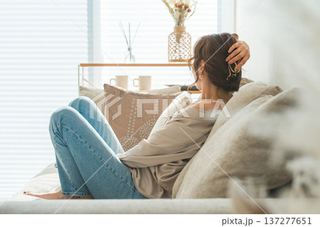 リビングのソファでリラックスするおしゃれな主婦のアジア人女性 リビングのソファでリラックスするおしゃれな主婦のアジア人女性 137277651