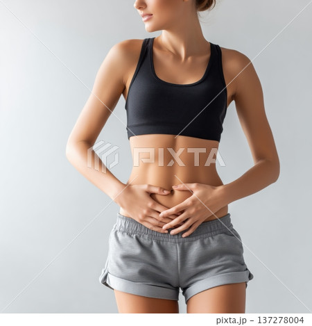 下腹部を押さえる女性の腹痛イメージ 137278004