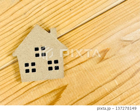 木目調のテーブルの上に茶色い家のオブジェ 137278149
