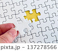 ジグソーパズルの最後のピースをはめる手元 137278566