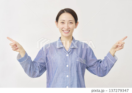 パジャマを着た女性 左右を指差す 白バック パジャマを着た女性 左右を指差す 白バック 137279347