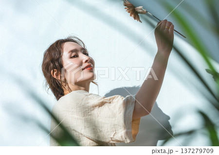 一輪のガーベラの花を持つ女性 一輪のガーベラの花を持つ女性 137279709