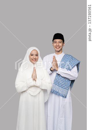 Peaceful Muslim couple praying. Tranquil Muslim couple performing traditional prayer gesture 137280561