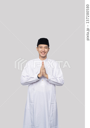 Respectful greeting gesture. Peaceful Asian Muslim man displaying respectful afro greeting gesture 137280580