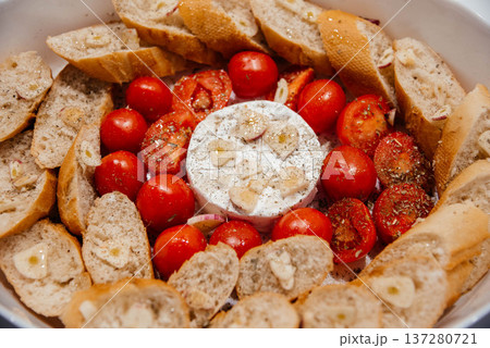 Camembert cheese baked with tomatoes and baguette, herbs and garlic. An excellent appetizer for wine. View from above. Camembert cheese baked with tomatoes and baguette, herbs and garlic. An excellent appetizer for wine. View from above. 137280721
