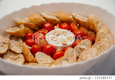 Camembert cheese baked with tomatoes and baguette, herbs and garlic. An excellent appetizer for wine. View from above.  137280737