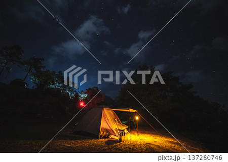nature traveling with orange camping tent on mountain with milky way and star background 137280746