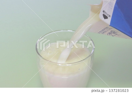 牛乳をグラスに注ぐ 137281023