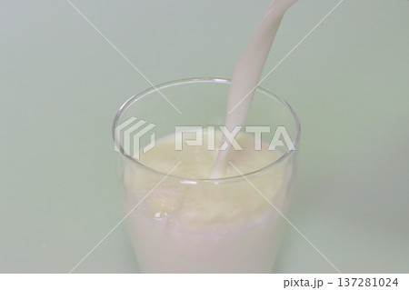 牛乳をグラスに注ぐ 137281024
