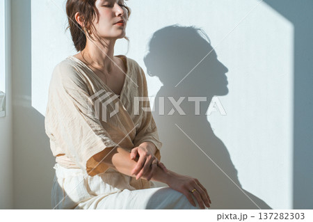 西陽の当たる窓辺にいる女性(モデル,ファッション,光,影) 西陽の当たる窓辺にいる女性(モデル,ファッション,光,影) 137282303