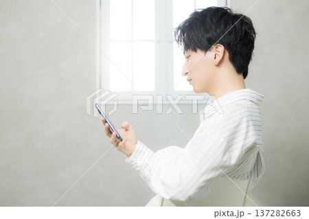 スマホを見る若い男性 137282663
