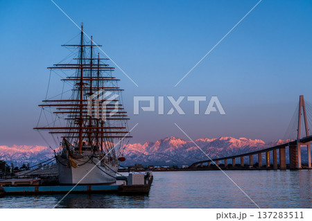 夕方の海王丸パークから新湊大橋と海王丸を前景にピンク色染まる立山連峰アーベンロート 137283511
