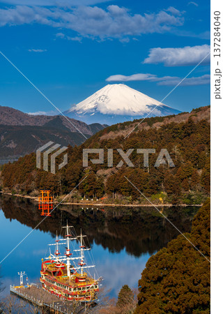 朝の芦ノ湖に浮かぶ遊覧船と雪をかぶった富士山 朝の芦ノ湖に浮かぶ遊覧船と雪をかぶった富士山 137284040