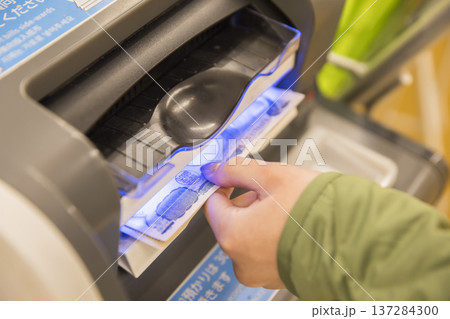 スーパーのレジにお金を投入する女性手元 スーパーのレジにお金を投入する女性手元 137284300