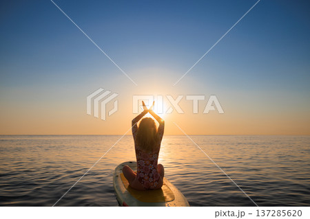 Young woman walking on sup board by the sea during summer vacation 137285620