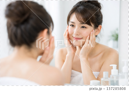 明るい洗面所で鏡を見ながら肌の状態をチェックする日本人女性 137285808