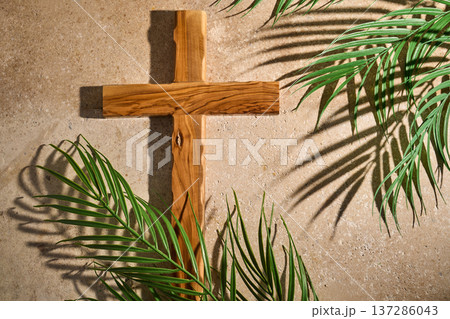 Wooden cross with palm leaves casting shadows 137286043