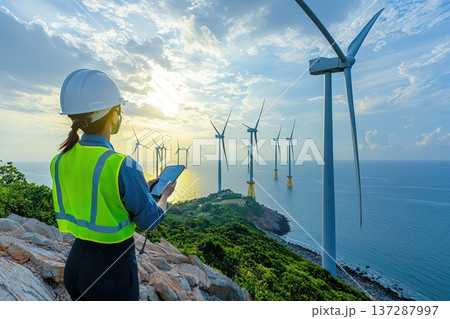 Technician in Neon Green Vest Inspecting Wind Farm Turbines by the Ocean Technician in Neon Green Vest Inspecting Wind Farm Turbines by the Ocean 137287997