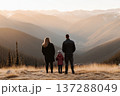 Family Standing on Mountain Top Overlooking Scenic Valley at Sunset in Tranquil Nature 137288049