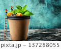 Giant Paper Cup Filled with Refreshing Summer Tea and Tiny Figurines Enjoying Nature 137288055