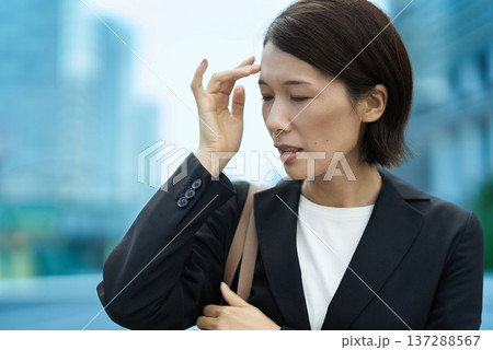 疲れた表情を見せるビジネスウーマン 137288567
