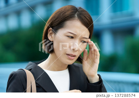 疲れた表情を見せるビジネスウーマン 137288574