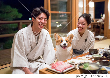 旅館で夕食を楽しむカップルとコーギー 137288764